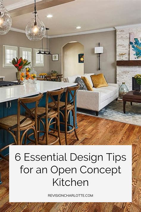 An Open Concept Kitchen And Living Room With Blue Cabinets White