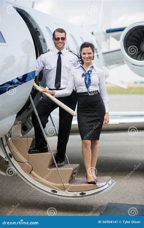 Aeromoça De Bordo Segura E Piloto Standing on Ladder Imagem de Stock