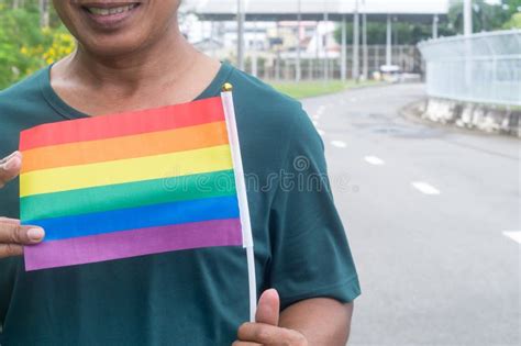Asian Ou Thai Gay Se Posicionando E Sorrindo A Bandeira Do Arco