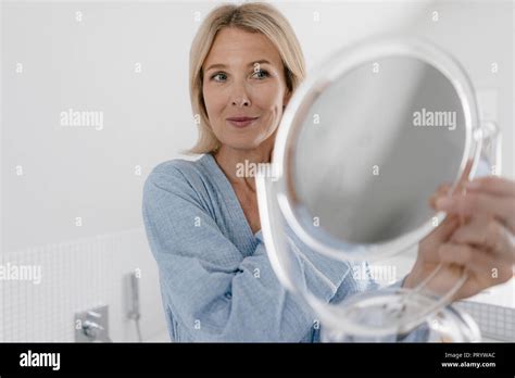 Mature Woman Looking In Beauty Mirror In Bathroom Stock Photo Alamy