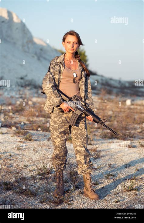 Young Beautiful Female Soldier Dressed In A Camouflage With A Gun In