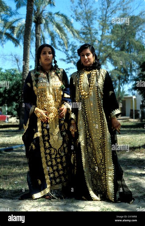 Two women in Bahrain wearing rich, gold embroidered dresses Stock Photo ...