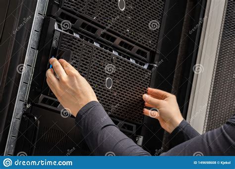 Close Up Of Hands Of It Consultant Installing Servers In Rack At