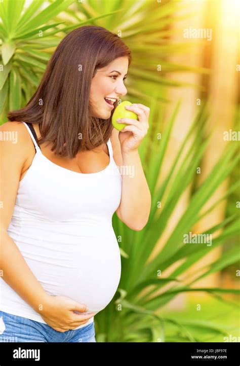 Portrait Of Beautiful Pregnant Woman Bite Apple Having Fun In Exotic