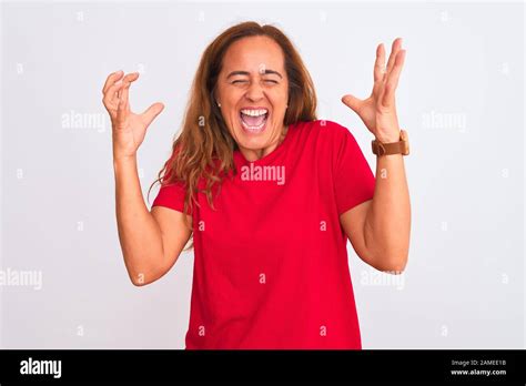L âge moyen mature woman standing over white background isolé et fou fou célèbre pour le succès
