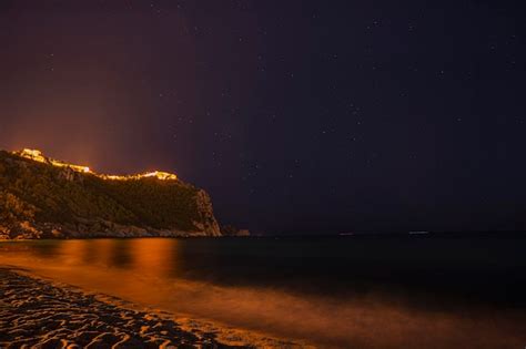 Premium Photo | A castle on the beach at night with the stars above