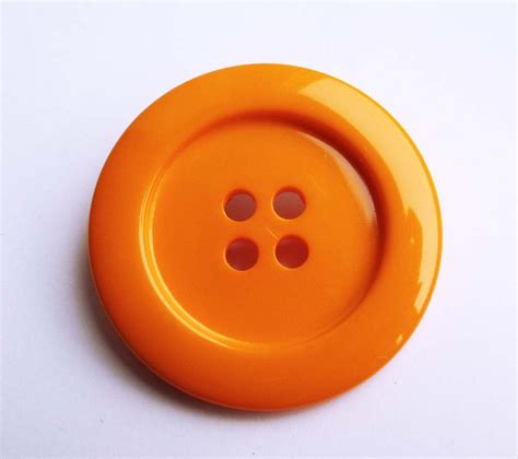 Orange Button on White Surface