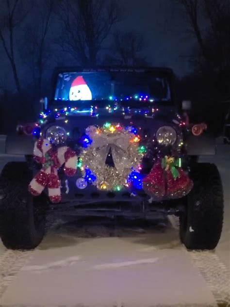 A Jeep Decorated For Christmas With Lights And Decorations On The Front