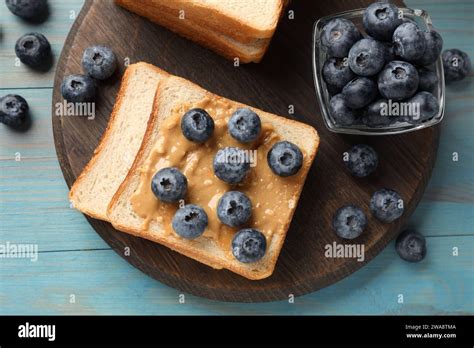 Delicious Toasts With Peanut Butter And Blueberries On Light Blue