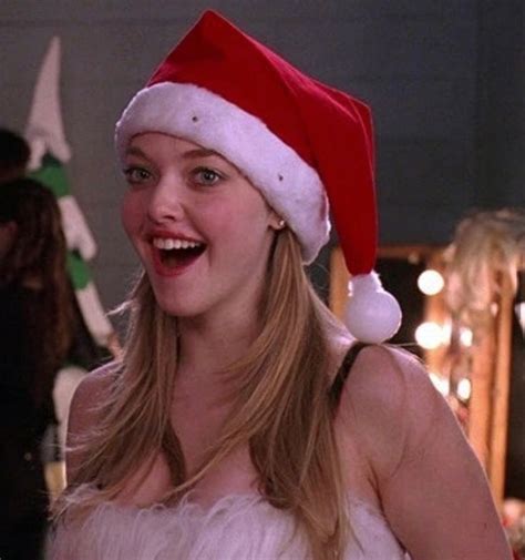 A Woman Wearing A Santa Hat And Smiling