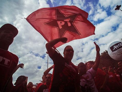 A Group Of People Standing Around Each Other Holding Up A Red And Black