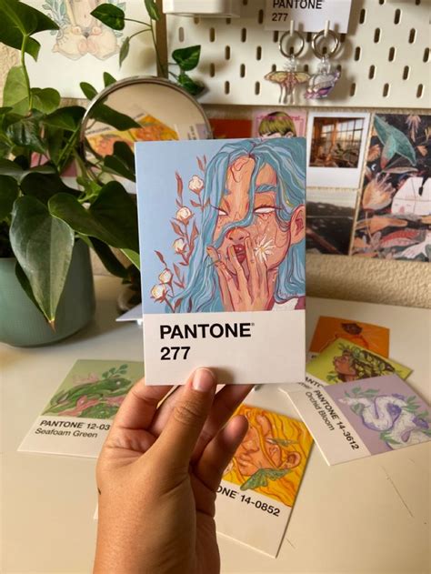 A Person Holding Up A Card With The Word Pantone On It