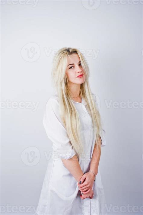 jolie blonde femme médecin ou infirmière en blouse de laboratoire isolée sur fond blanc