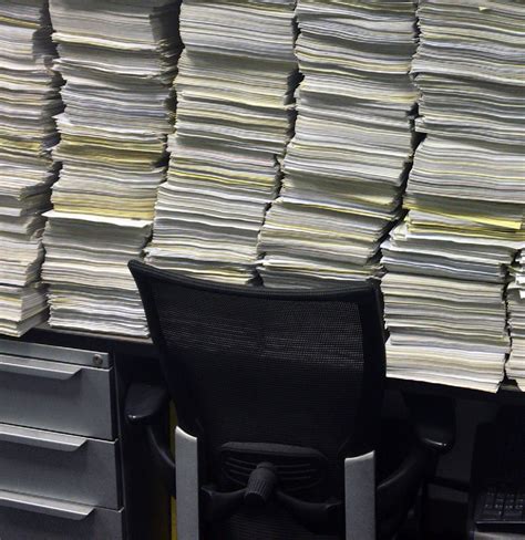 High Paper Stacks On Desk One View