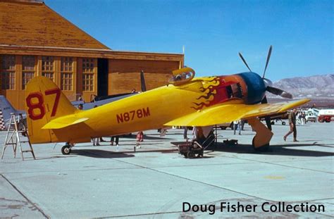 A Yellow Airplane Parked In Front Of A Building