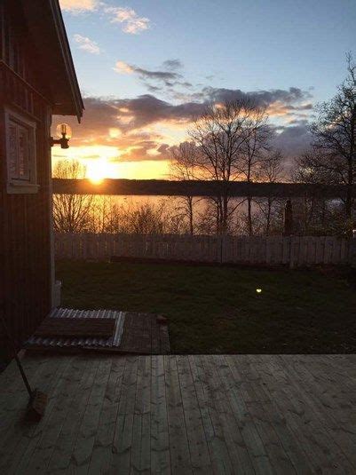 The Sun Is Setting Over A Backyard With A Deck