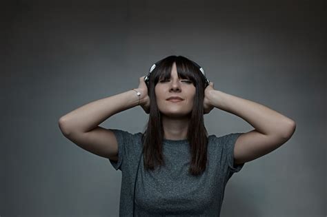 Free Photo Young Woman Holding Headphones With Closed Eyes