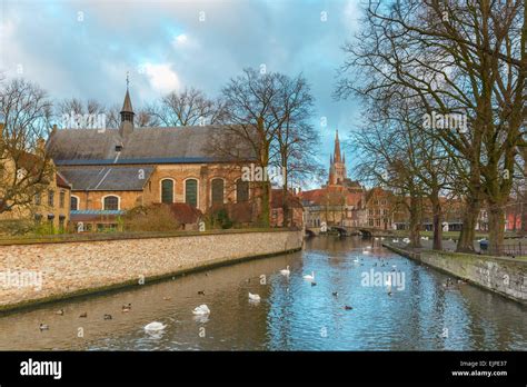 Landscape At Lake Minnewater And Church In Bruges Belgium Stock Photo