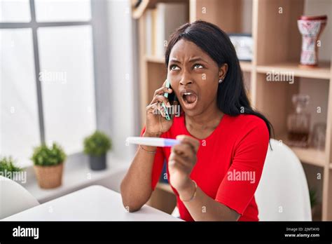 African Young Woman Holding Pregnancy Test Result Speaking On The Phone