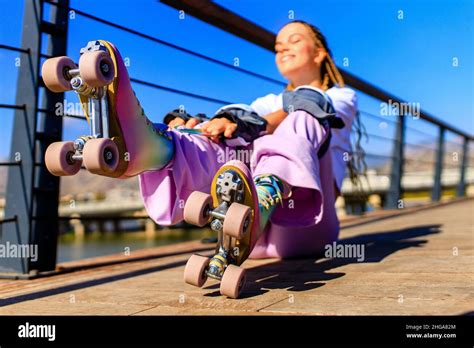 Happy Woman With Long Blonde Braids Hair On The Roller Skate In The