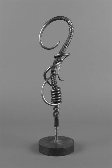 A Metal Sculpture On Top Of A Black Base With A Spiral Design In The Middle