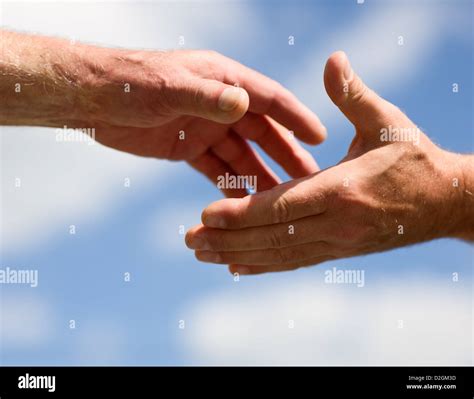 Two Hands Reaching Out To Each Other Against Sky Stock Photo Alamy