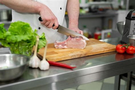 Chef Cortando La Carne En Una Tabla De Madera Foto Premium