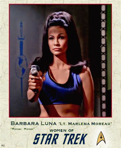 A Woman Holding A Cell Phone In Front Of A Star Trek Poster With The