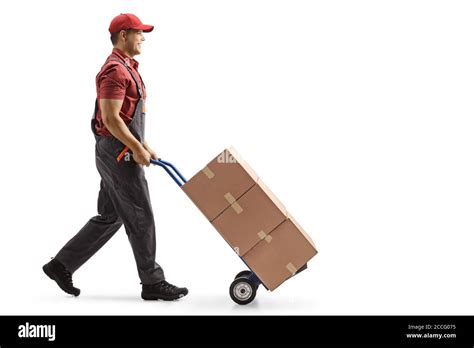 Full Length Profile Shot Of A Male Worker Pushing Boxes On A Hand Truck