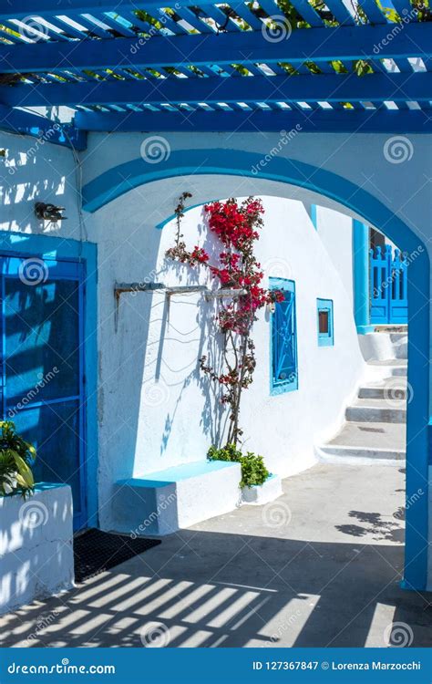 Traditional Greek Architecture With Whitewashed Walls And Blue Pergola