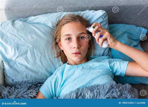 Sick Teenage Little Girl With High Fever And Headache Laying In Bed