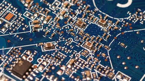 Circuit board with components in rotation. Close up of blue electronic ...