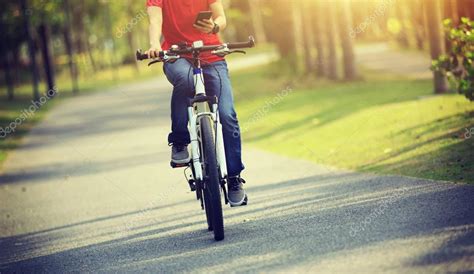 Ciclista Que Utiliza El Tel Fono Celular Mientras Monta En Bicicleta En