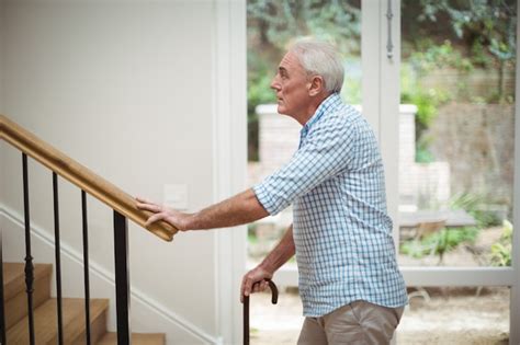 Premium Photo Senior Man Climbing Upstairs With Walking Stick