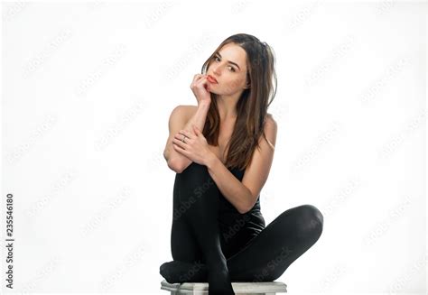 Beautiful Long Haired Brunette In Dark Tights Sits On The Chair In The Studio Attractive Woman