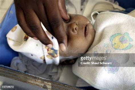 A Mother Closes The Eyes Of Her Deceased Baby In The Morgue On