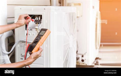 Air conditioner repairman using electricity meter to check air ...