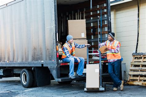 Two Workers With A Truck Moving Furniture Boxes Stock Photo Download