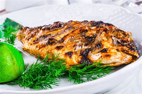 Grilled Dorado Fish With Lemon And Sauce On Wooden Board Stock Photo