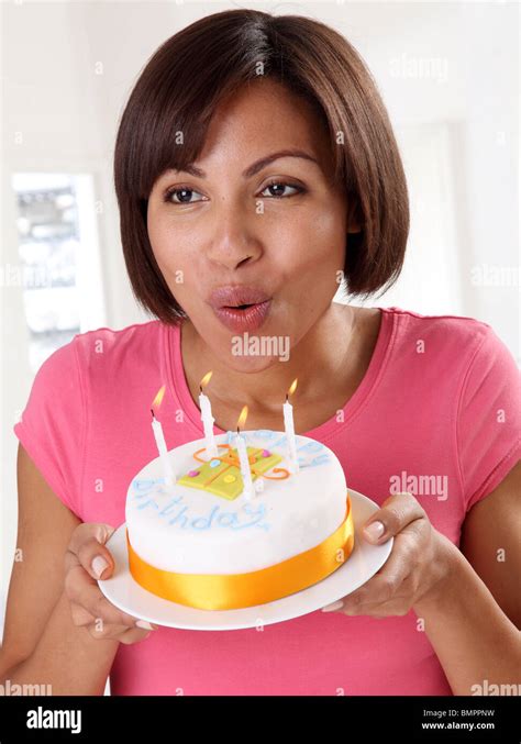 WOMAN BLOWING OUT CANDLES ON BIRTHDAY CAKE Stock Photo Alamy