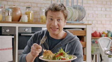 A Man Holding A Fork And Knife In His Hand While Eating Food From A Bowl