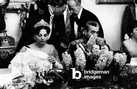 Farah Pahlavi And Mohammad Reza Pahlavi Sitting At The Table By