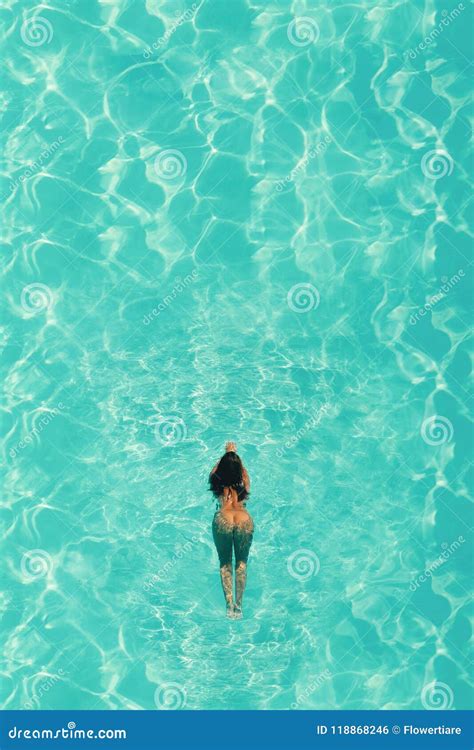 Aerial Top View Of Naked Woman In Swimming Pool With Blue Water In