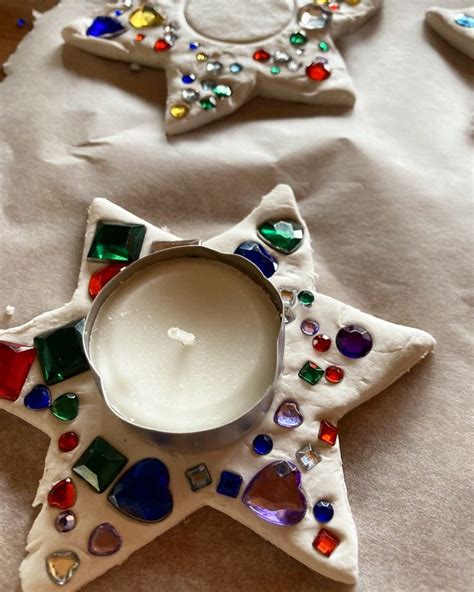 A White Candle Sitting On Top Of A Table Next To Some Ornaments And