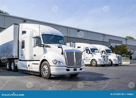 Row Of The Big Rig Semi Trucks Tractors With Dry Van Semi Trailers