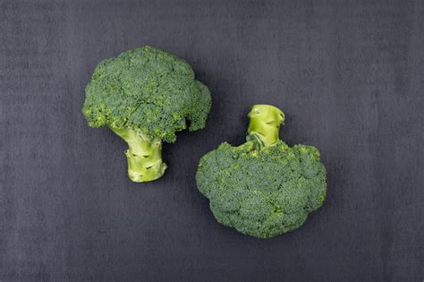 Free Photo Top View Two Bunches Of Broccoli On Black Surface