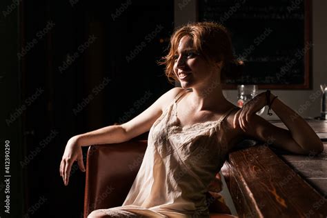 Red Headed Caucasian Woman In Lingerie Sitting On Dimly Lit Barstool Stock Photo Adobe Stock