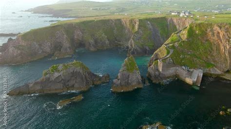 Dunquin or Dun Chaoin pier, Ireland's Sheep Highway. Aerial view of narrow pathway winding down ...