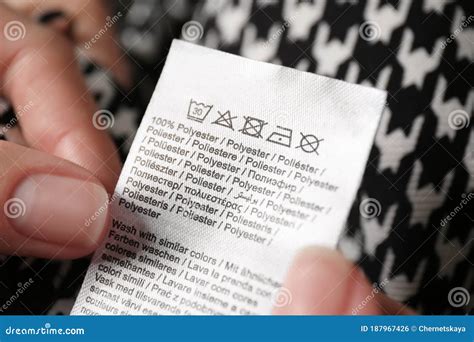 Woman Reading Clothing Label With Care Symbols And Material Content On