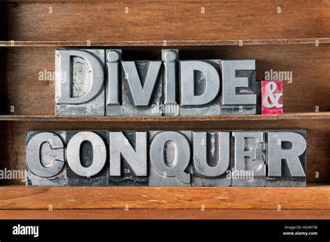 Divide And Conquer Phrase Made From Metallic Letterpress Type On Wooden